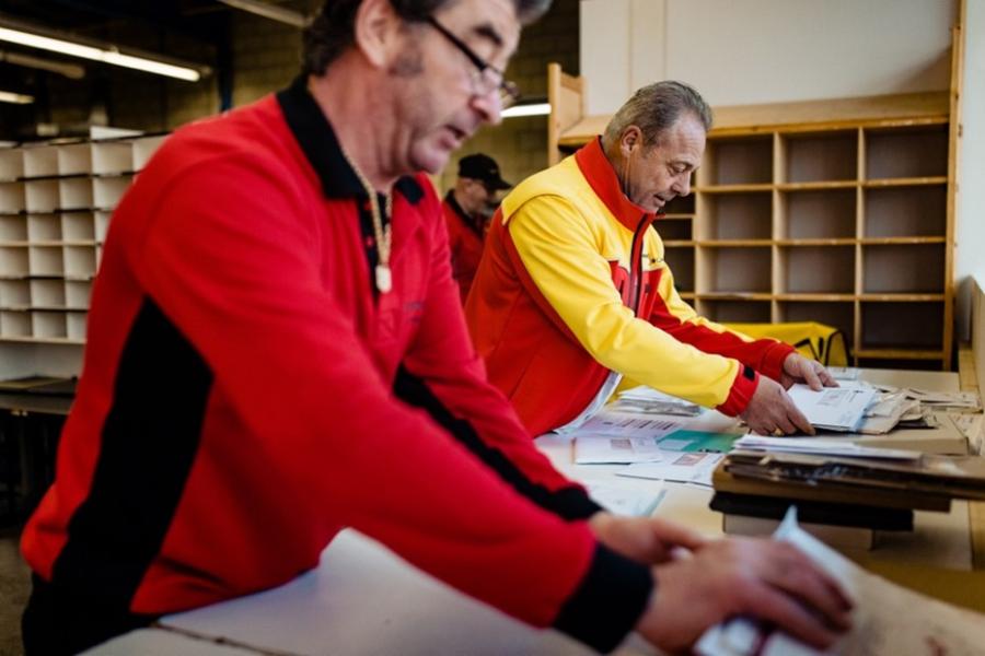 twee medewerkers van Businesspost aan het werk in het sorteercentrum