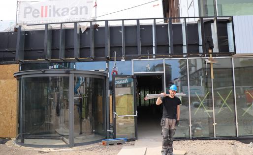 Bjorn sjouwt met steigerbuizen op bouwplaats vie