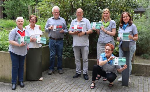 Groepsfoto van alle receptionisten met cadeau voor dag van receptionist