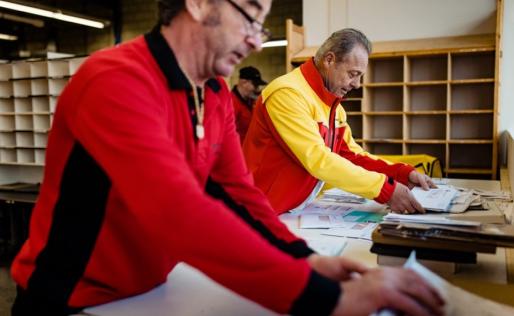 twee medewerkers van Businesspost aan het werk in het sorteercentrum