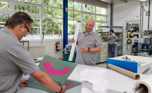twee medewerkers van Impreso aan het werk in de drukkerij