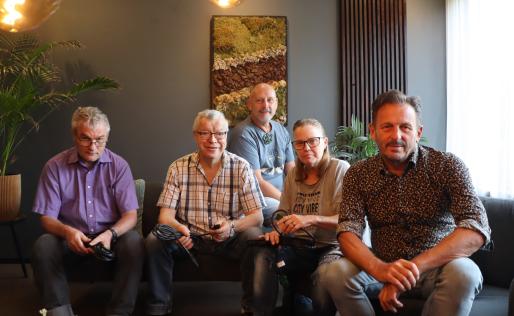 Groepsfoto van medewerkers op de bank in de studio 