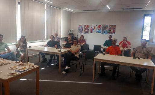 Alle aanwezigen zitten in de zaal en luisteren naar de presentatie