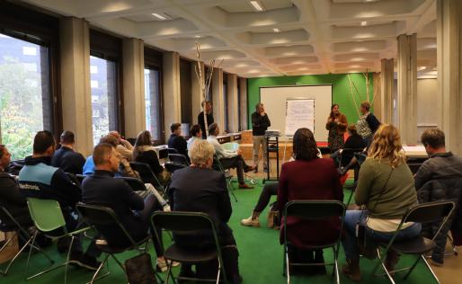 Deelnemers aan de sessie kijken naar presentatie