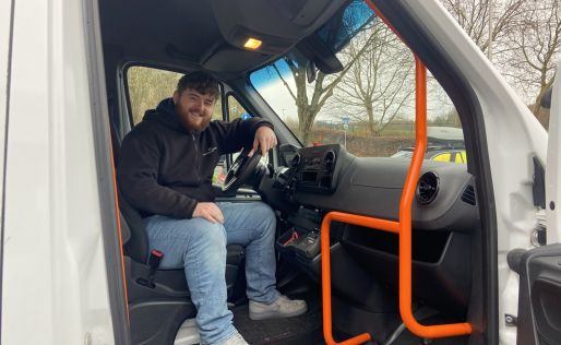 Skender achter het stuur als taxichauffeur in het groepsvervoer