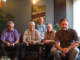 Groepsfoto van medewerkers op de bank in de studio 