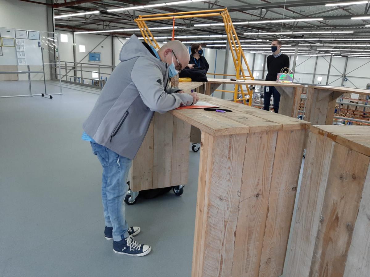 Melvin zet handtekening onder diploma tot logistiek medewerker