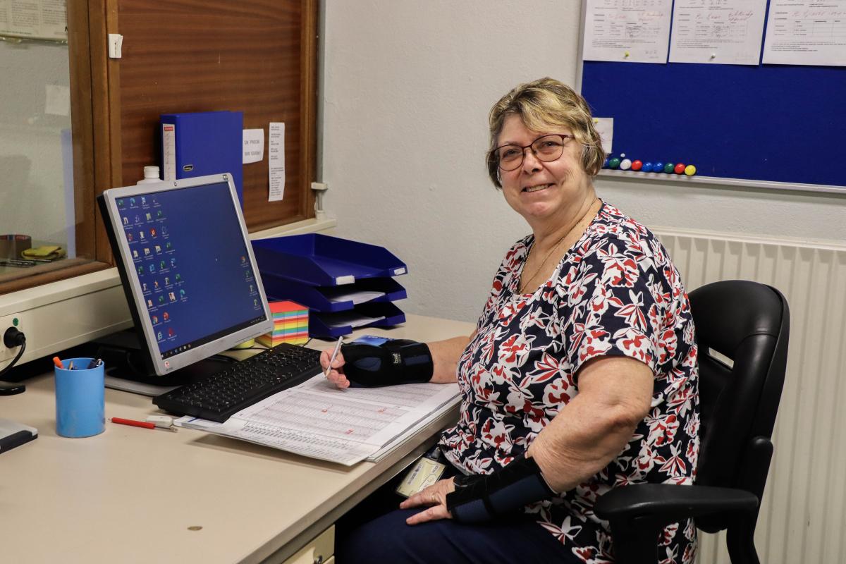 Voorvrouw Jeanny achter de computer op haar werkplek