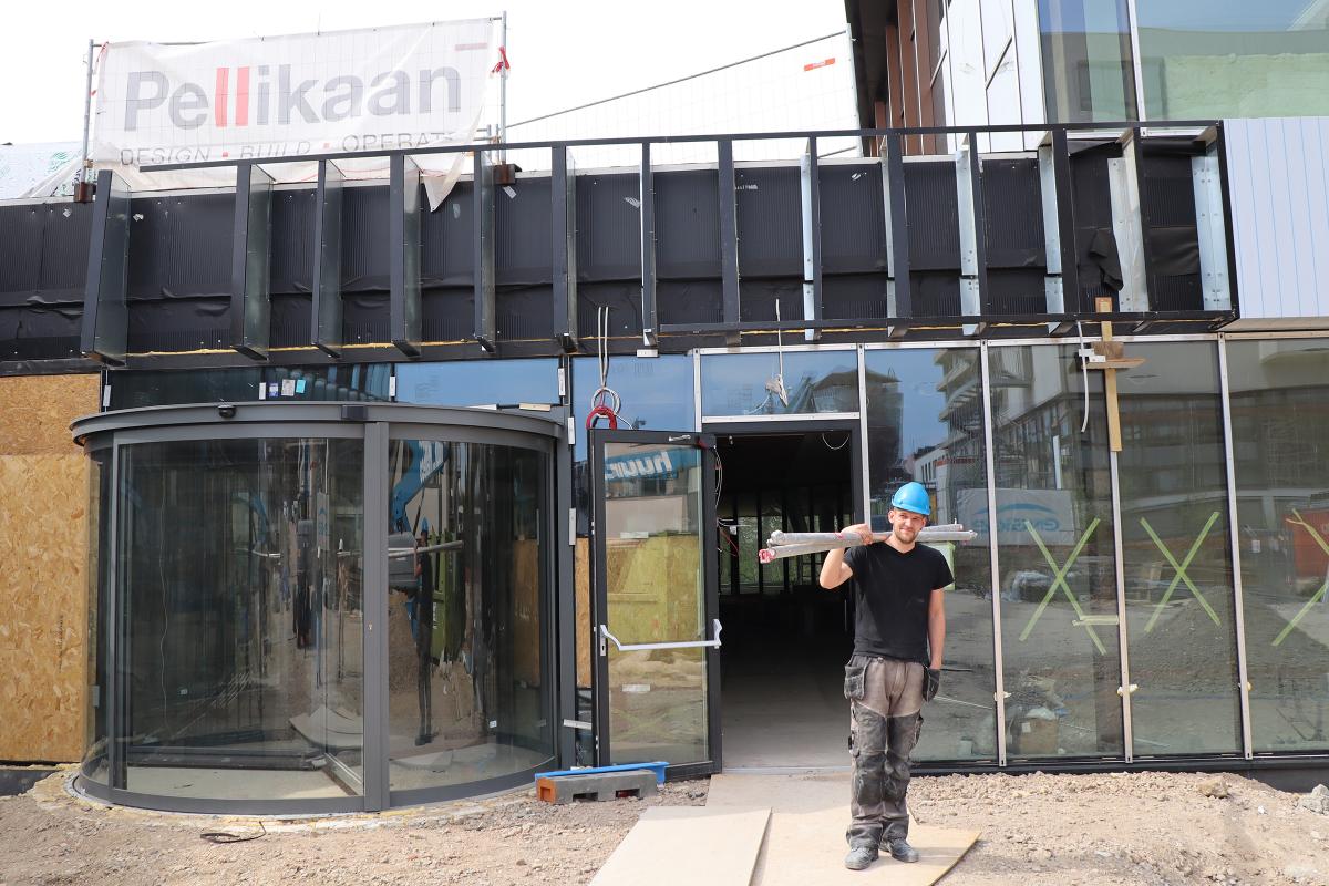 Bjorn sjouwt met steigerbuizen op bouwplaats vie