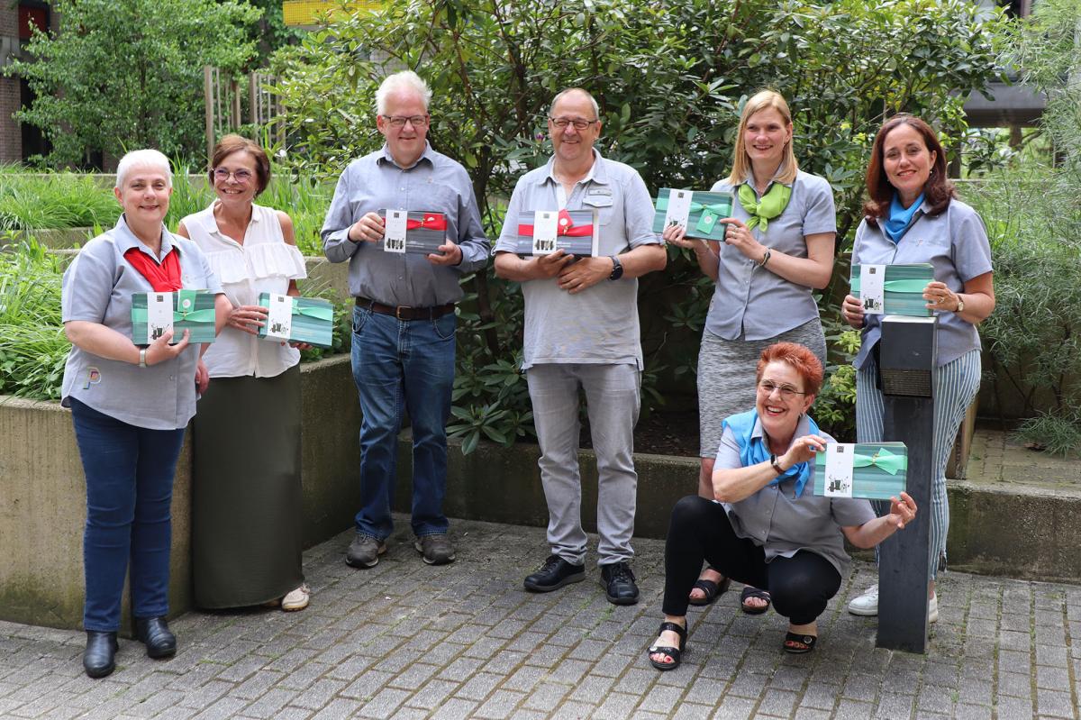 Groepsfoto van alle receptionisten met cadeau voor dag van receptionist