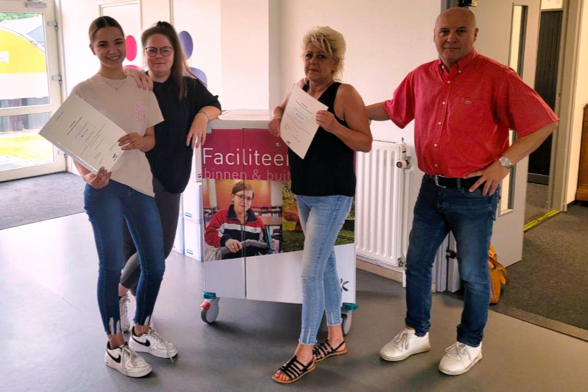 Hafsa met diploma in handen met begeleiders Rebecca, Marion en Helmut