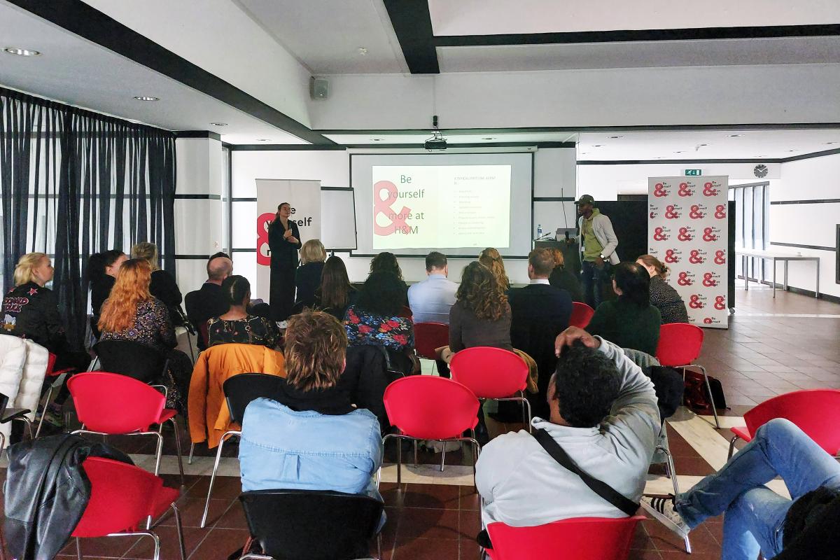 Consulenten en kandidaten luisteren naar presentatie van recruiter van H&M