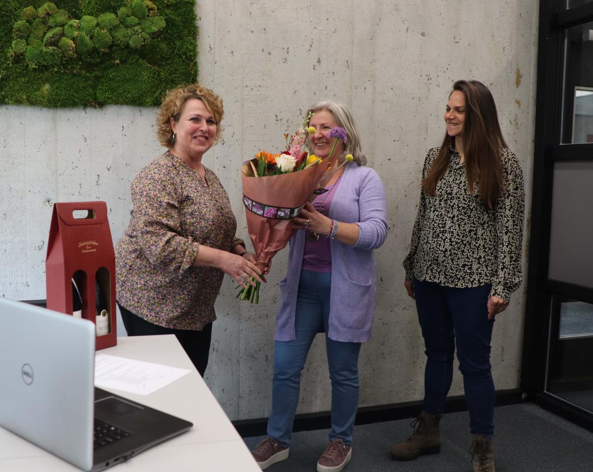 Dionne Eijdems en Maya Gloudemans overhandigen bloemen aan Anita van Dormalen 