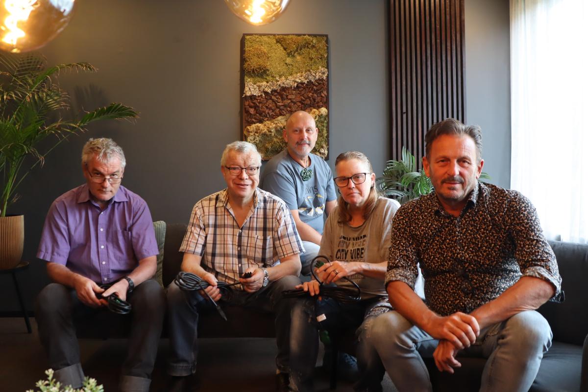 Groepsfoto van medewerkers op de bank in de studio 