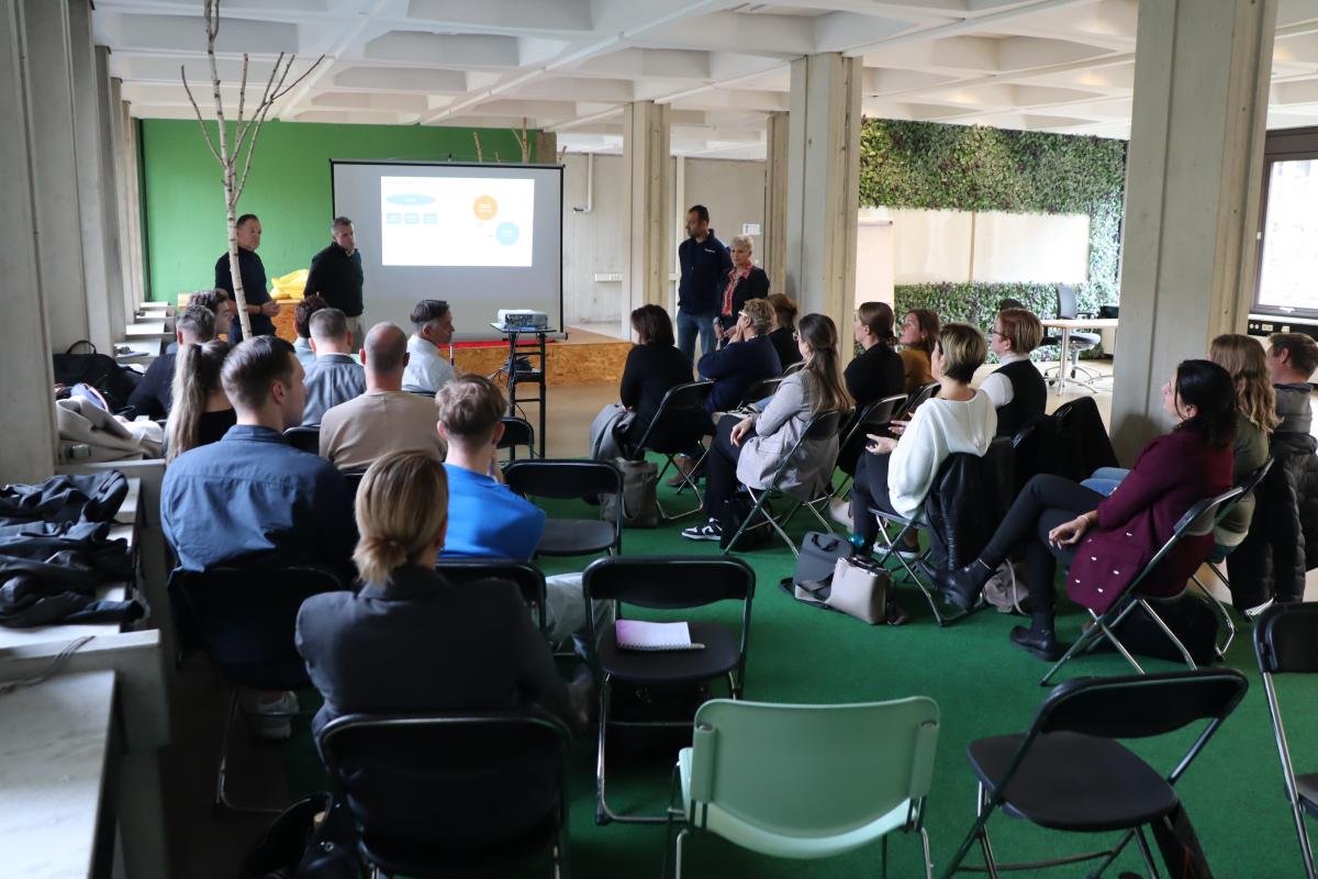 Deelnemers aan de sessie kijken naar presentatie