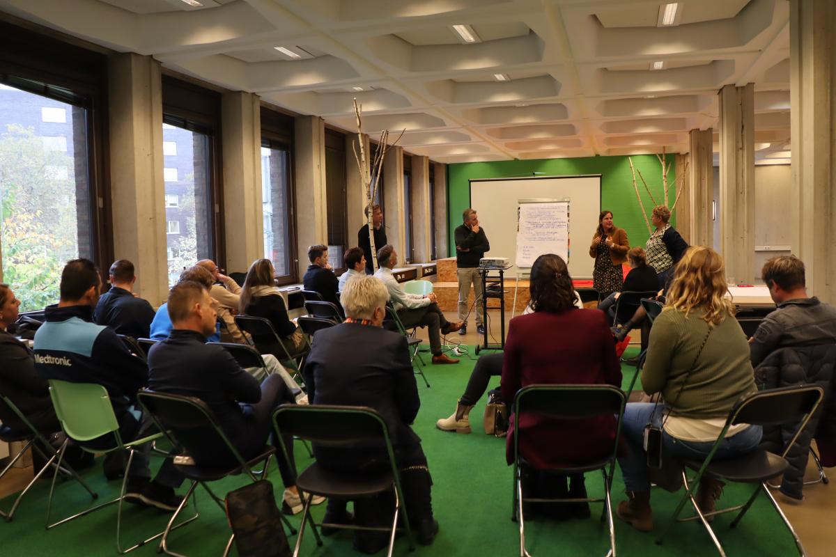 Deelnemers aan de sessie kijken naar presentatie