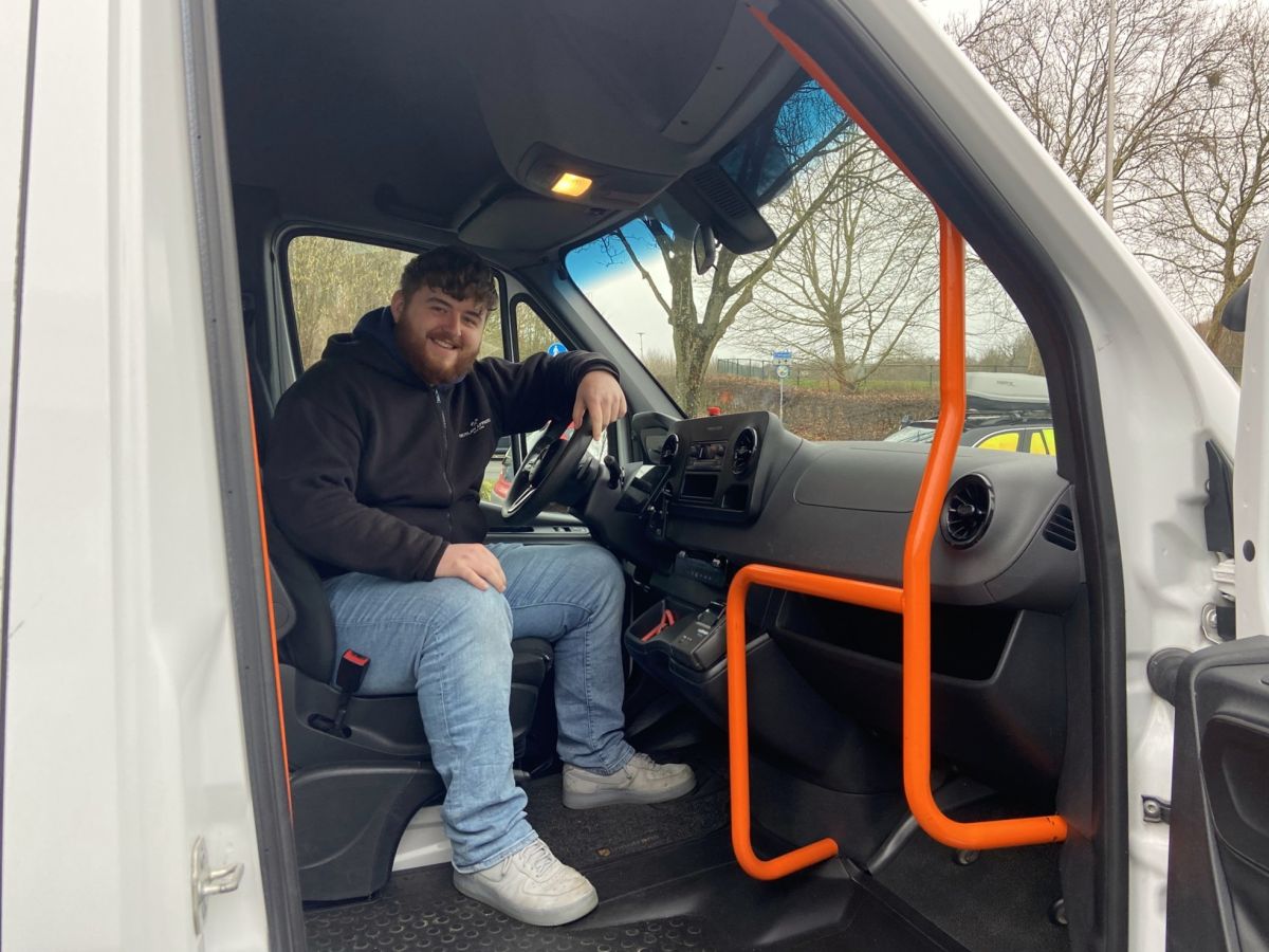 Skender achter het stuur als taxichauffeur in het groepsvervoer