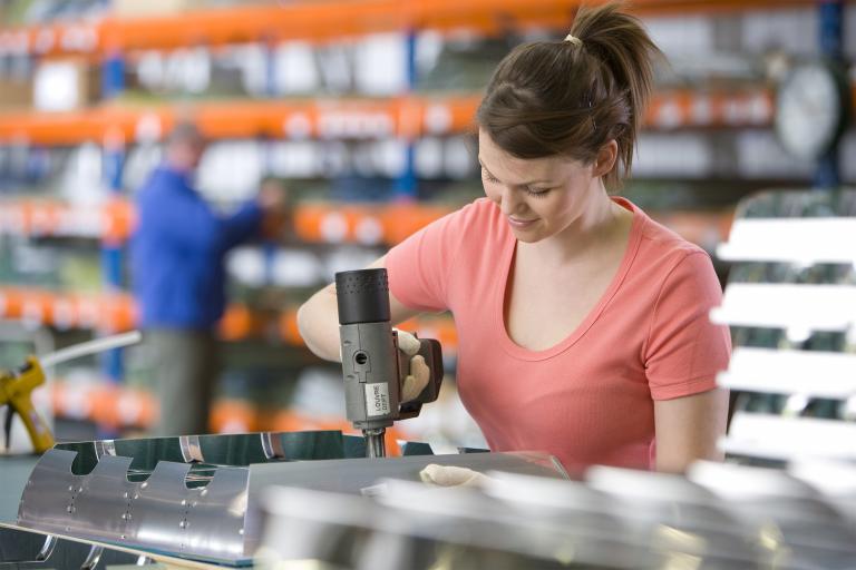 Jonge dame werkzaam in fabriek