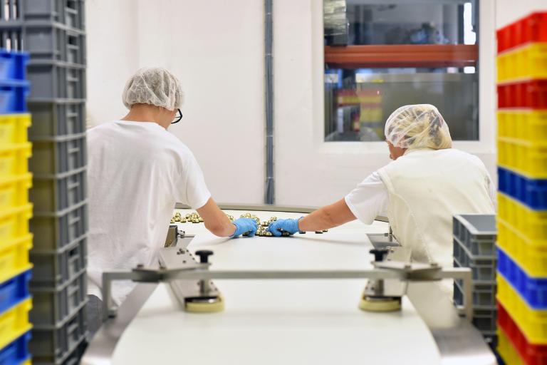 Twee medewerkers in werkplaats aan de lopende band