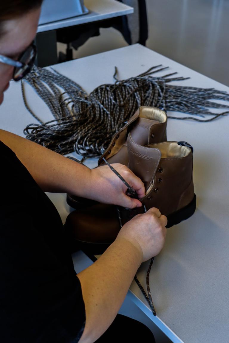 Medewerker doet veters in werkschoen