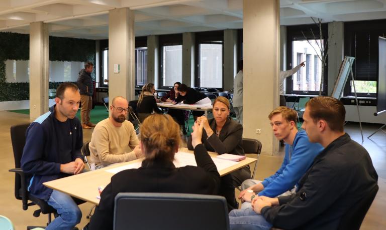 Deelnemers brainstormen in groepjes